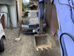 ショベルにて引きずりだされる放置車両のセルシオ
